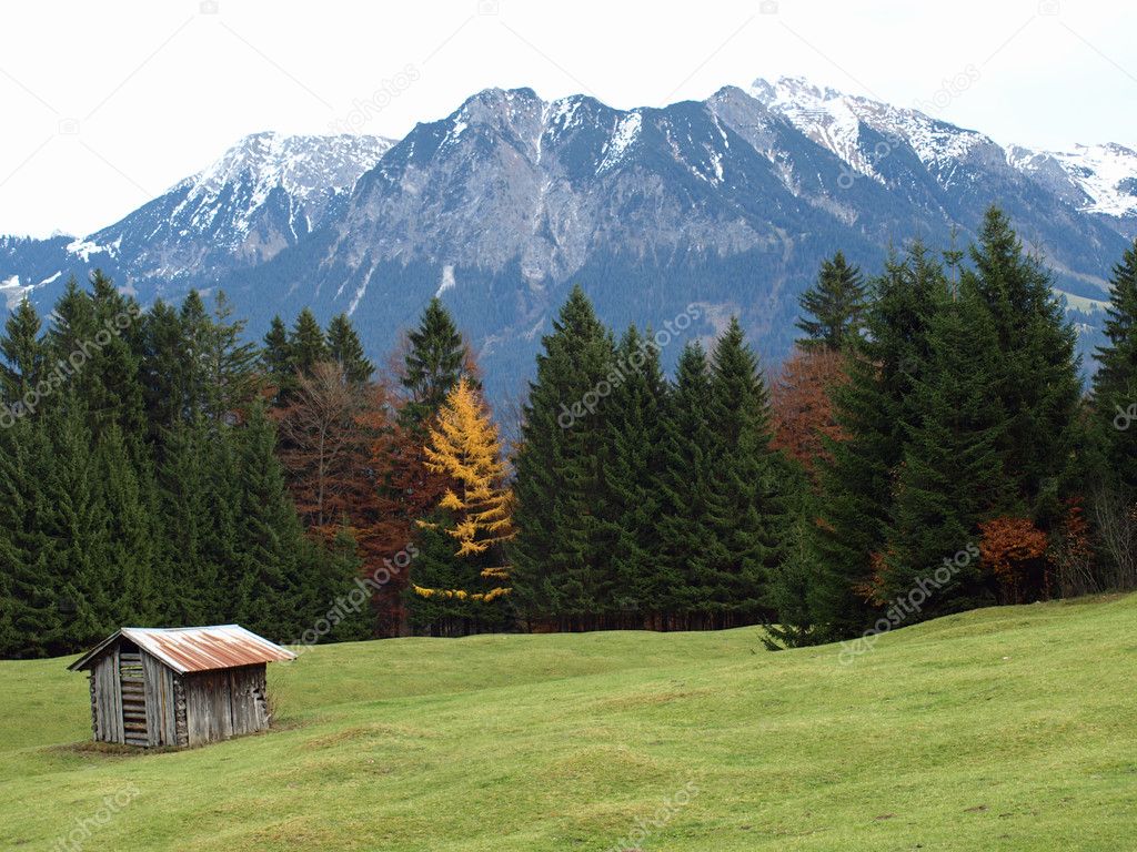 mountains close to the city of oberstdorf in germany with a shed in the front