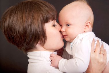 Mother kissing her little baby clipart