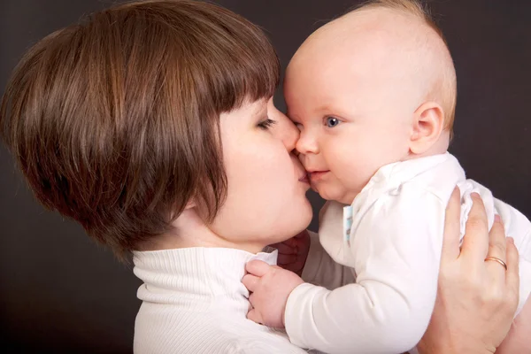 Mãe beijando seu bebê pequeno — Fotografia de Stock