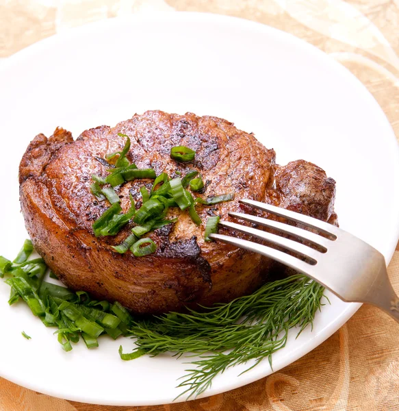 Leckeres gebratenes Steak mit Kräutern Stockbild