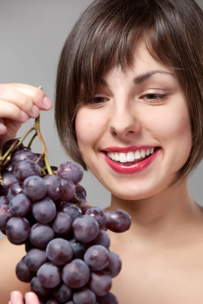 Girl with a bunch of grapes — Stock Photo, Image