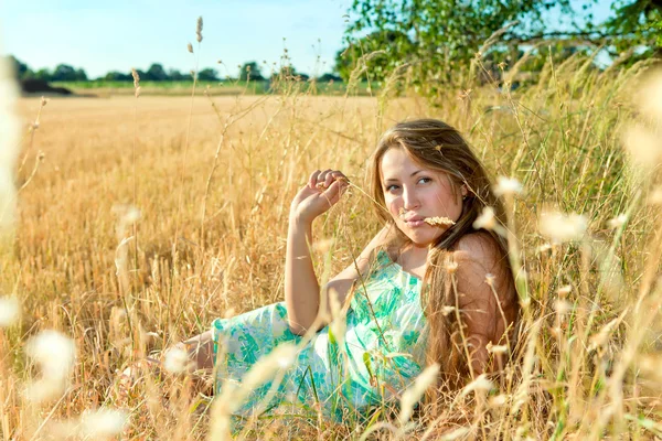 Mladá žena v trávě v létě — Stock fotografie