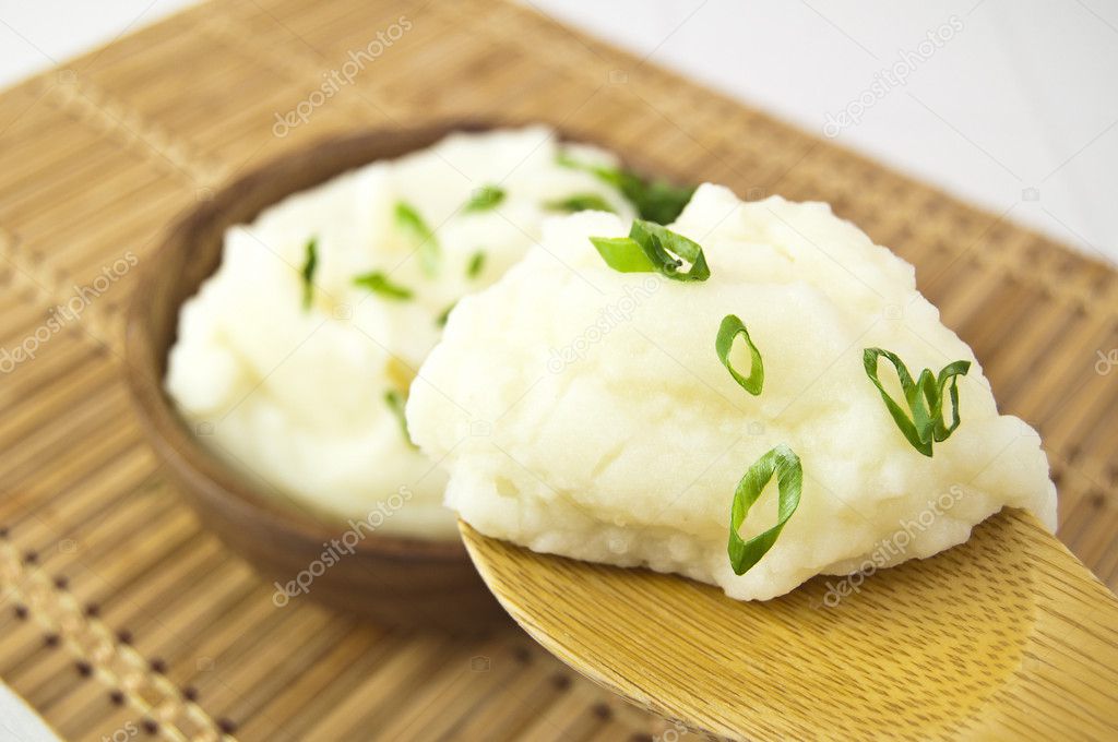 Mashed potatoes in wooden spoon on a table