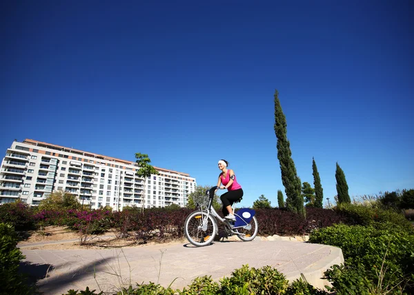 Młoda kobieta, jazda na rowerze w parku — Zdjęcie stockowe