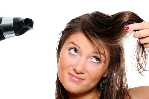 Молода жінка намагається чистити волосся — стокове фото