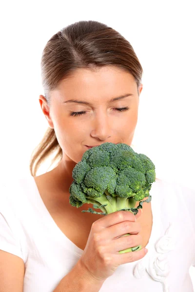 Ung kvinde, der lugter broccoli - Stock-foto