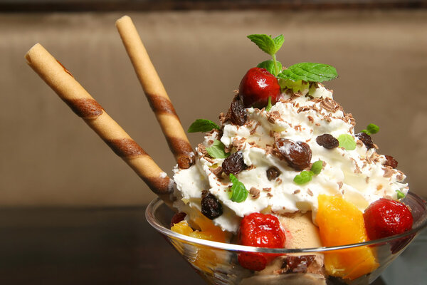 Bowl with ice cream and fruits on the wooden table