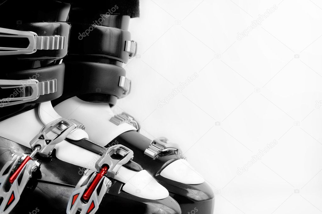 Black and red ski boots over white background