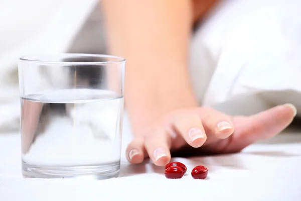 Närbild Kvinnlig Hand Når För Några Tabletter Över Vit Bakgrund — Stockfoto