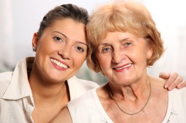 A beautiful portrait of grandma and grandaughter smiling over white background clipart