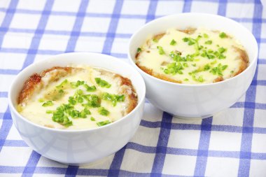 A picture of two bowls of onion soup standing on a table clipart