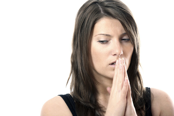 A portrait of a young frightened woman praying against white background