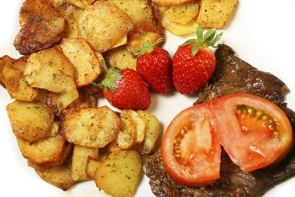Beef steak with sliced potatoes and strawberries — Stock Photo, Image