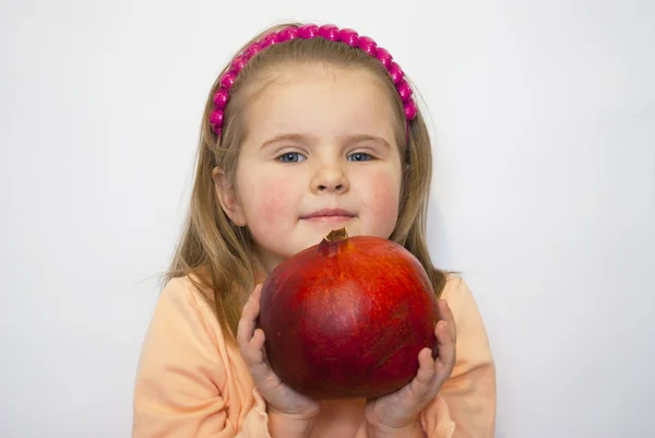 The beautiful girl holds a huge pomegranate in hands — Stock Photo, Image