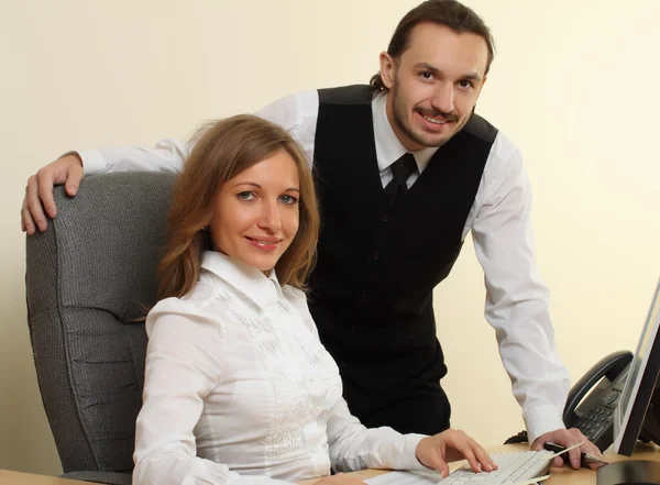 Бизнесмен и деловая женщина улыбаются с помощью компьютера — стоковое фото