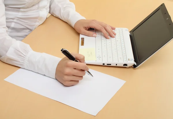 Женские руки и ноутбук с ручкой — стоковое фото