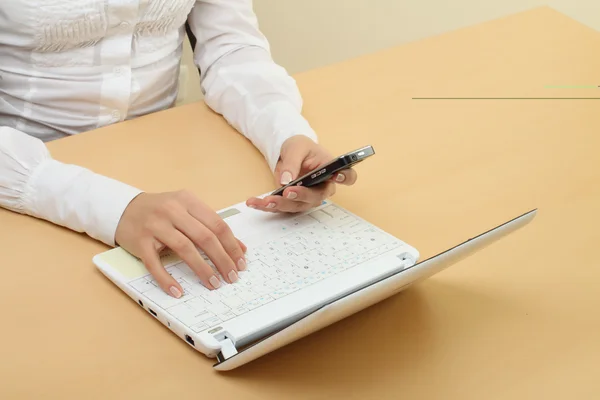 Mani femminili e laptop con cellulare — Foto Stock
