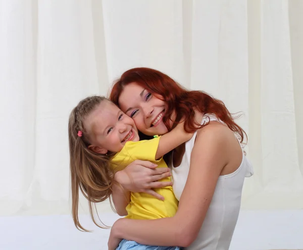 Porträtt av mor och dotter embracing hemma — Stockfoto