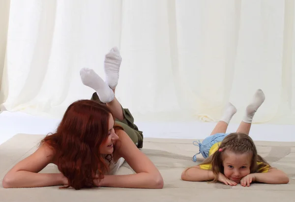 Madre e hija tendidas en el suelo en casa —  Fotos de Stock