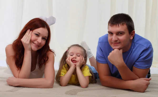 Familia feliz tendida en el suelo en casa —  Fotos de Stock