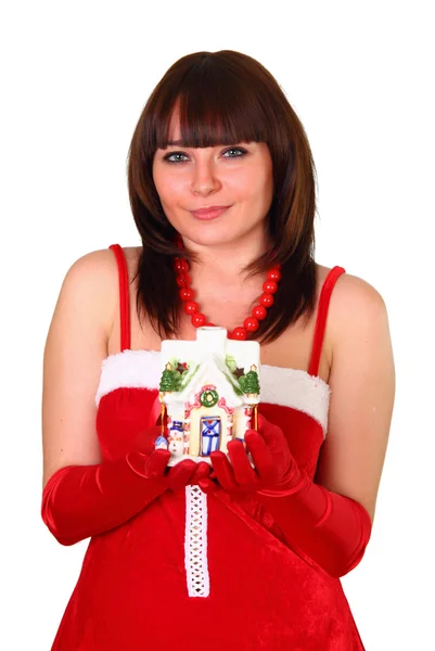 Brünettes Mädchen im Weihnachtsmann-Kleid gibt ein Spielzeug als Haus dekoriert — Stockfoto
