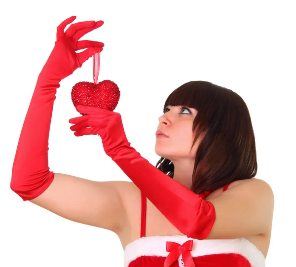 stock image Brunette girl in santa dress holding a heart chistmas decoration