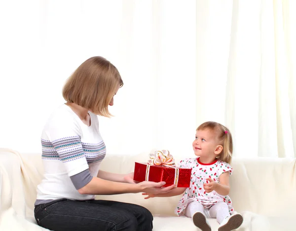 Mãe dá presente para seu dauthter em caixa vermelha em casa — Fotografia de Stock