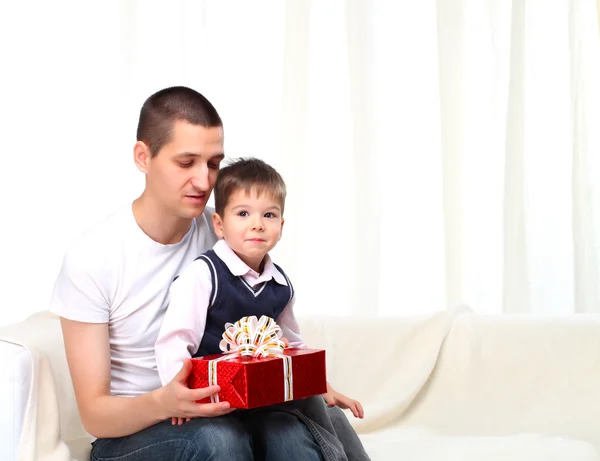 父は赤いボックス自宅で息子にプレゼントを与える — ストック写真