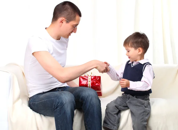 父は赤いボックス自宅で息子にプレゼントを与える — ストック写真