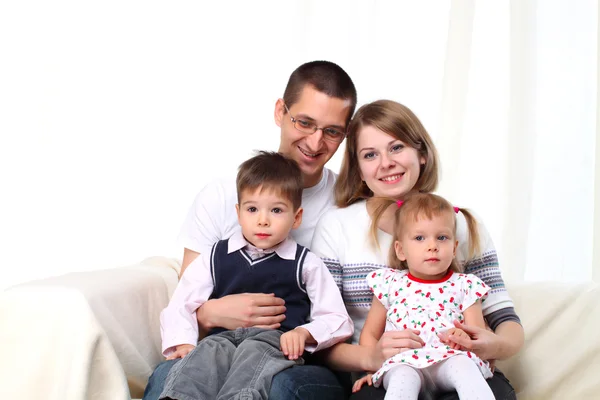 Portrait of happy family sitting on sofa — Stock Photo, Image