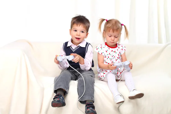 小男孩和女孩在沙发上玩电视游戏 — 图库照片#