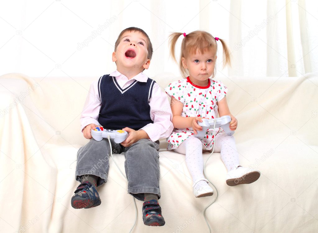 Little boy and girl playing tv game on sofa