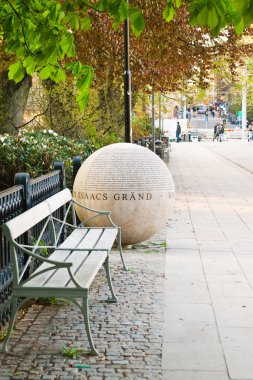 A large stone bowl with inscriptions like rolls out of the park on the street in Stockholm clipart