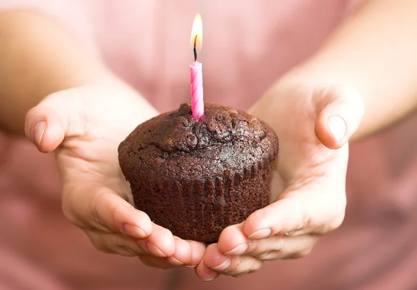 Dziewczyna oferuje Państwu muffin czekolady z świeca — Zdjęcie stockowe