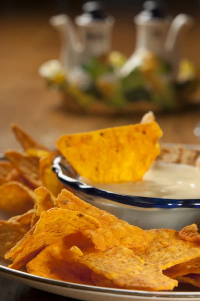 Plate of fresh nachos with a spicy white cheese sauce — Stock Photo, Image