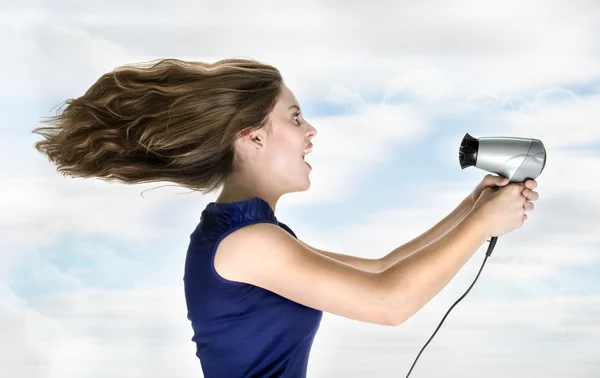 Frau trocknet Haare mit elektrischem Ventilator lizenzfreie Stockbilder