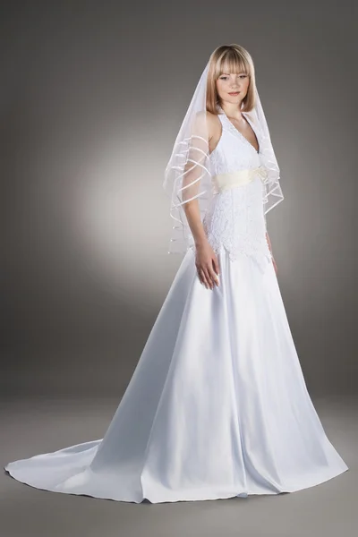 Mooie bruid in de bruiloft jurk en sluier — Stockfoto