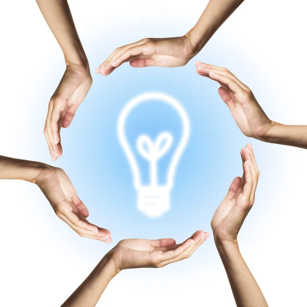 Glowing light bulb surrounded by hands — Stock Photo, Image