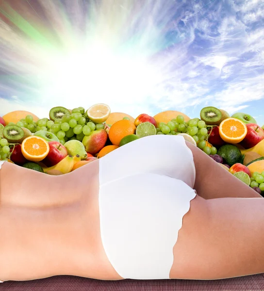 Corpo de mulher sobre frutas frescas e céu ensolarado — Fotografia de Stock