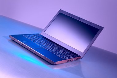 koyu kırmızı bir arka plan yansıması ile laptop