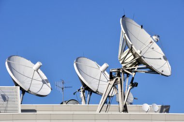 Satellite Communications Dishes on a Roof clipart