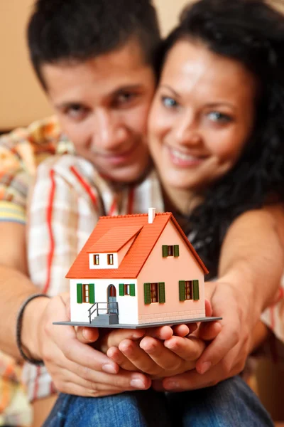 Šťastný pár s miniaturní dům — Stock fotografie