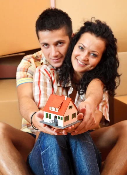 Lyckliga paret med miniatyr hus — Stockfoto