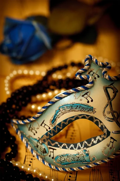 Máscara de carnaval ornamentada em um papel de música com rosa e pérolas — Fotografia de Stock