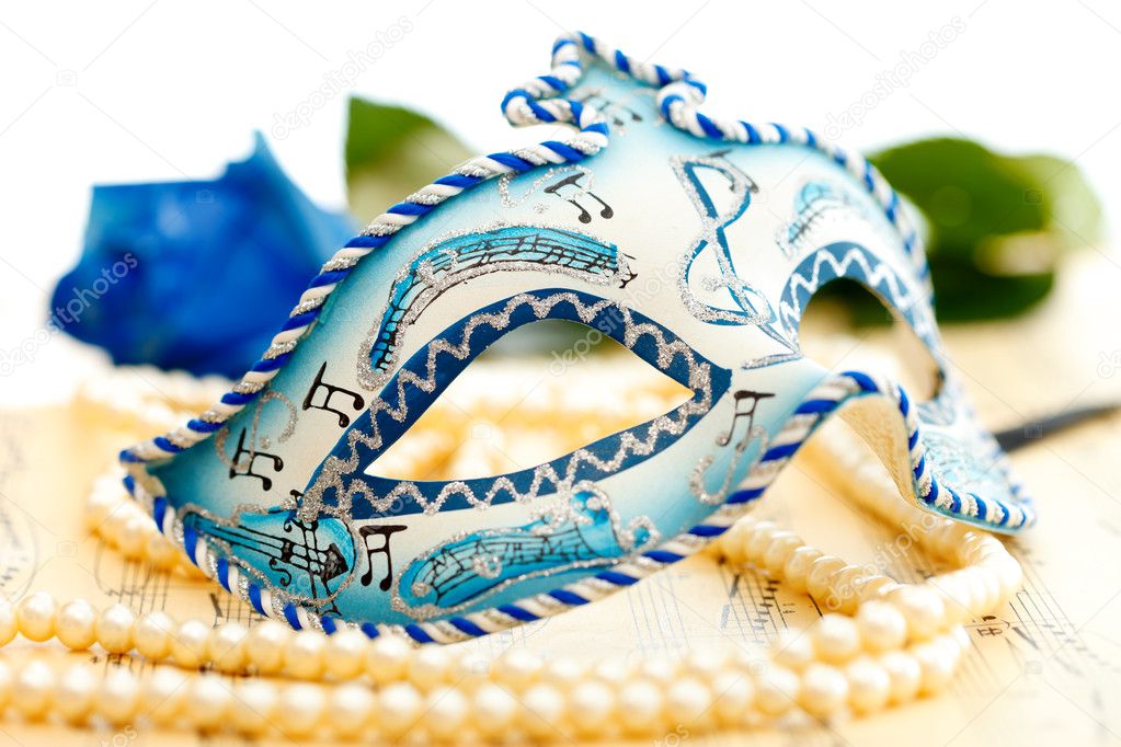Blue and white carnival mask on a music paper with blue rose on the background