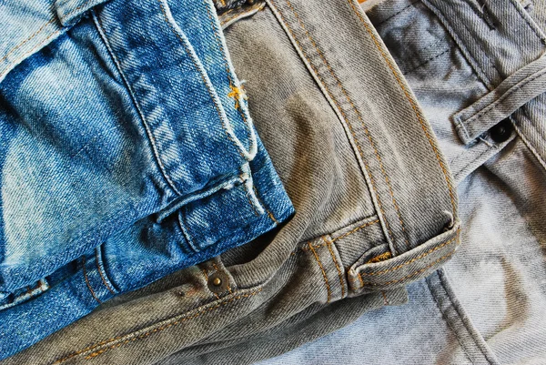 Tres pantalones vaqueros color pila fondo imagen — Foto de Stock