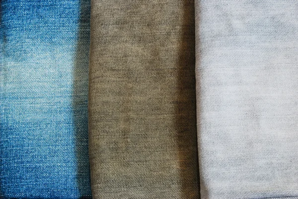 Tři barevné džíny hromadu obrázek pozadí textury — Stock fotografie