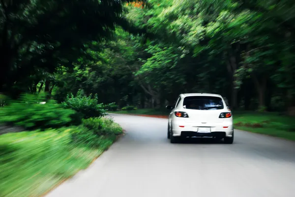 Velocità di guida a seguito di auto bianca sulla strada — Foto Stock