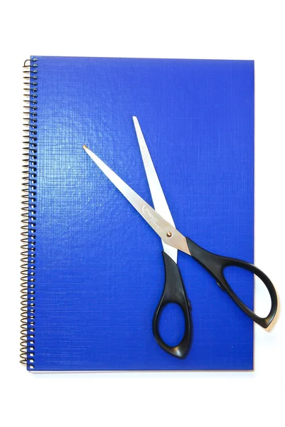 Tmavomodrá notebook s nůžkami, samostatný — Stock fotografie
