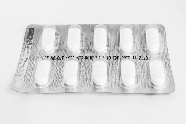 Пакет белых таблеток на белом фоне — стоковое фото